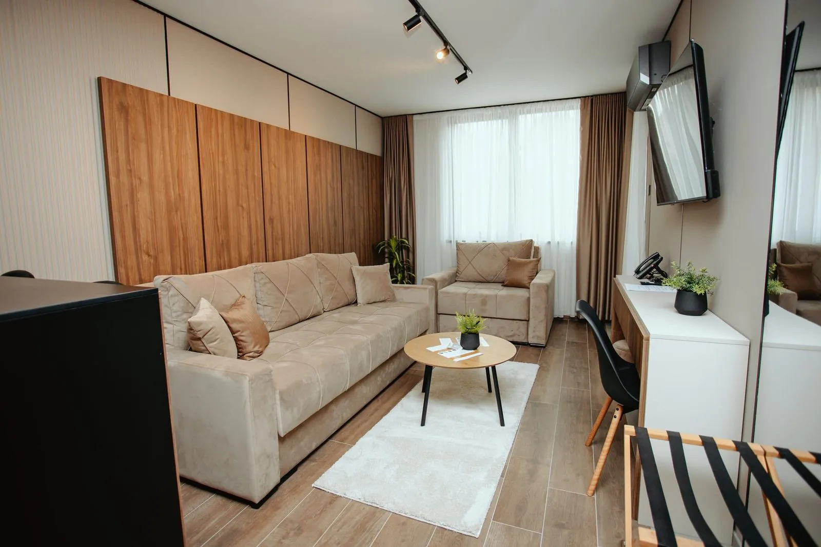 Living room of the superior apartment, sofa, armchair and TV on a swivel mount