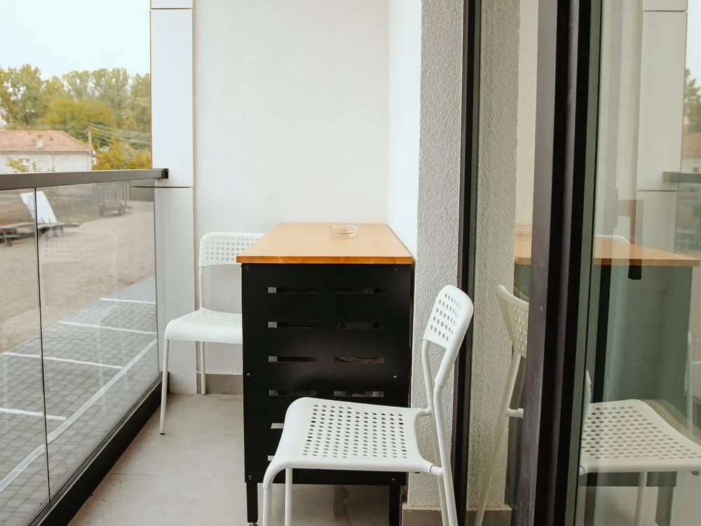 Balkon apartmana sa stolom i dve stolice