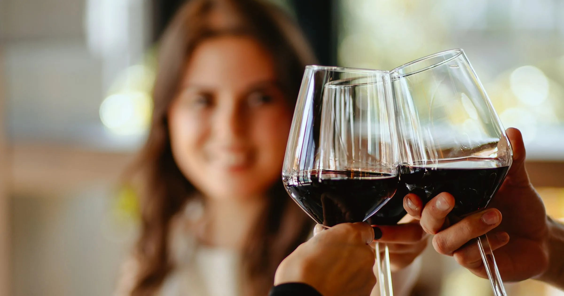Two guests raising glasses of red wine at Žar&So restaurant