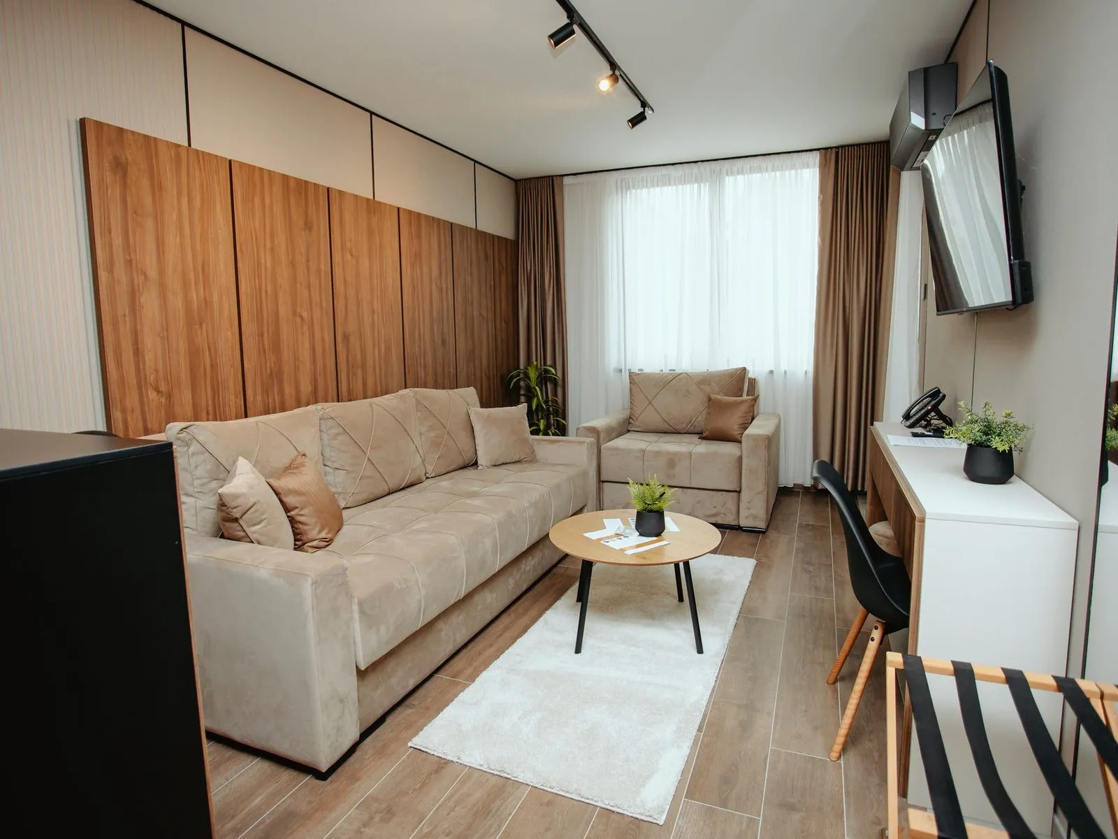 Superior apartment with a sofa, armchair and a wood-panelled wall