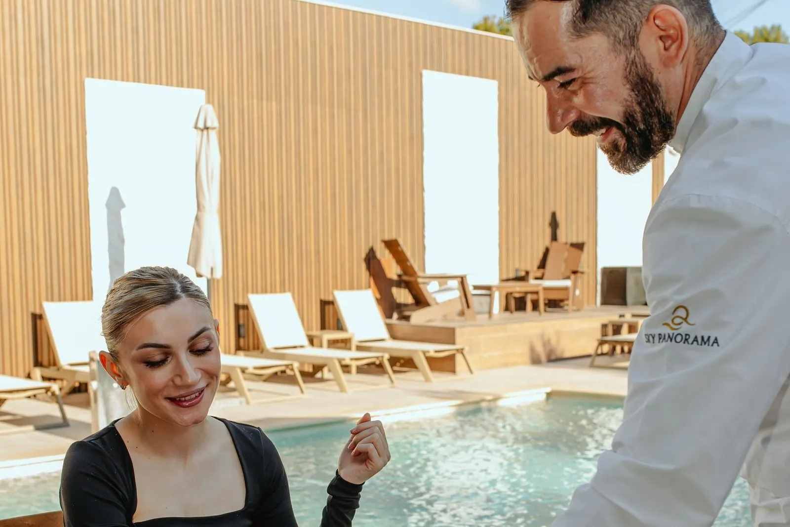 Waiter bringing dessert to a poolside table