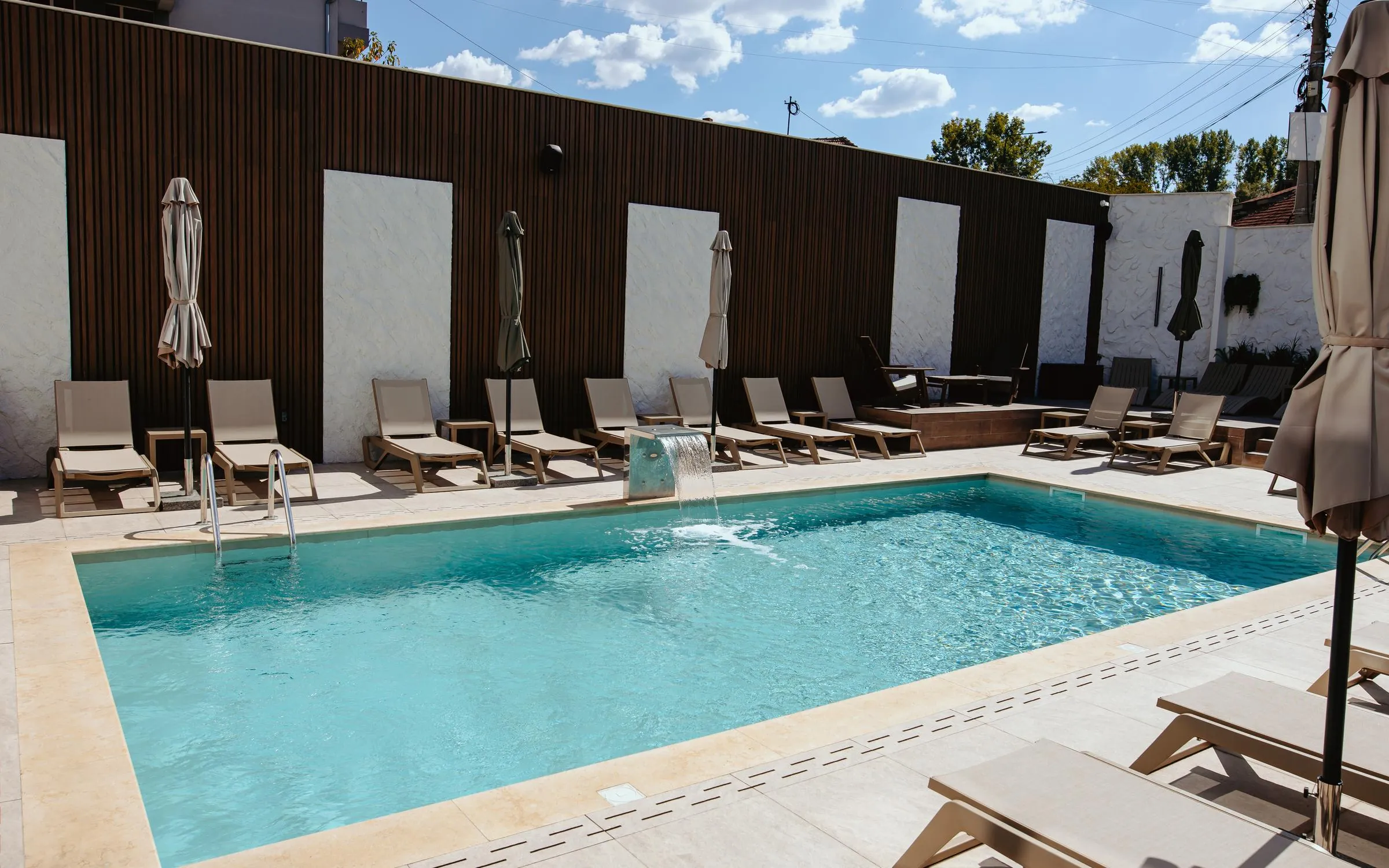 The hotel outdoor pool with sun loungers and umbrellas