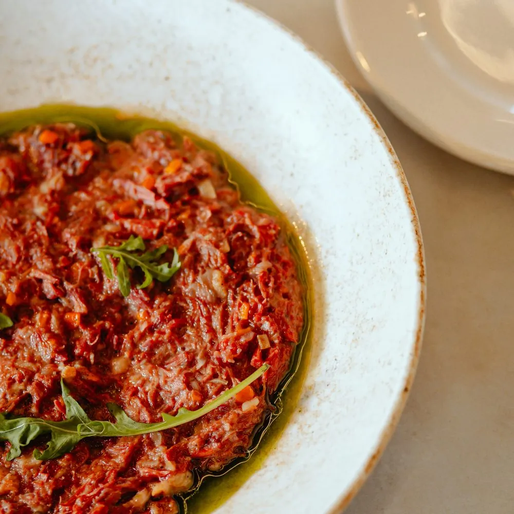 Starter in a ceramic bowl, with rocket and olive oil