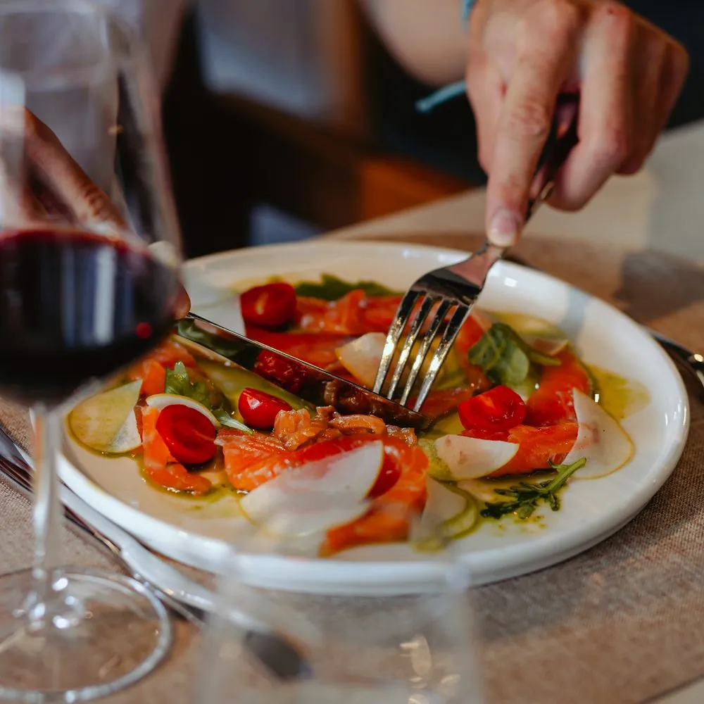 Salmon salad with cherry tomatoes and a glass of red wine