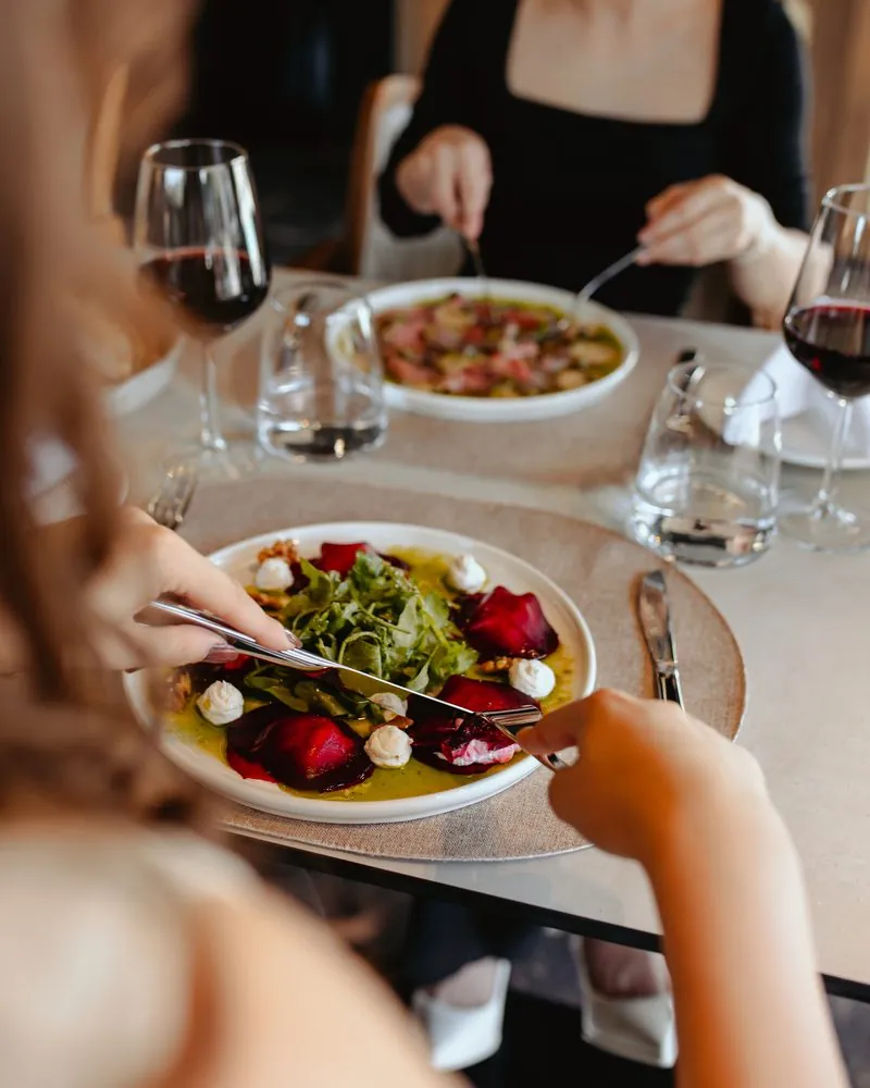 Beetroot salad with rocket and cheese, at a table with guests
