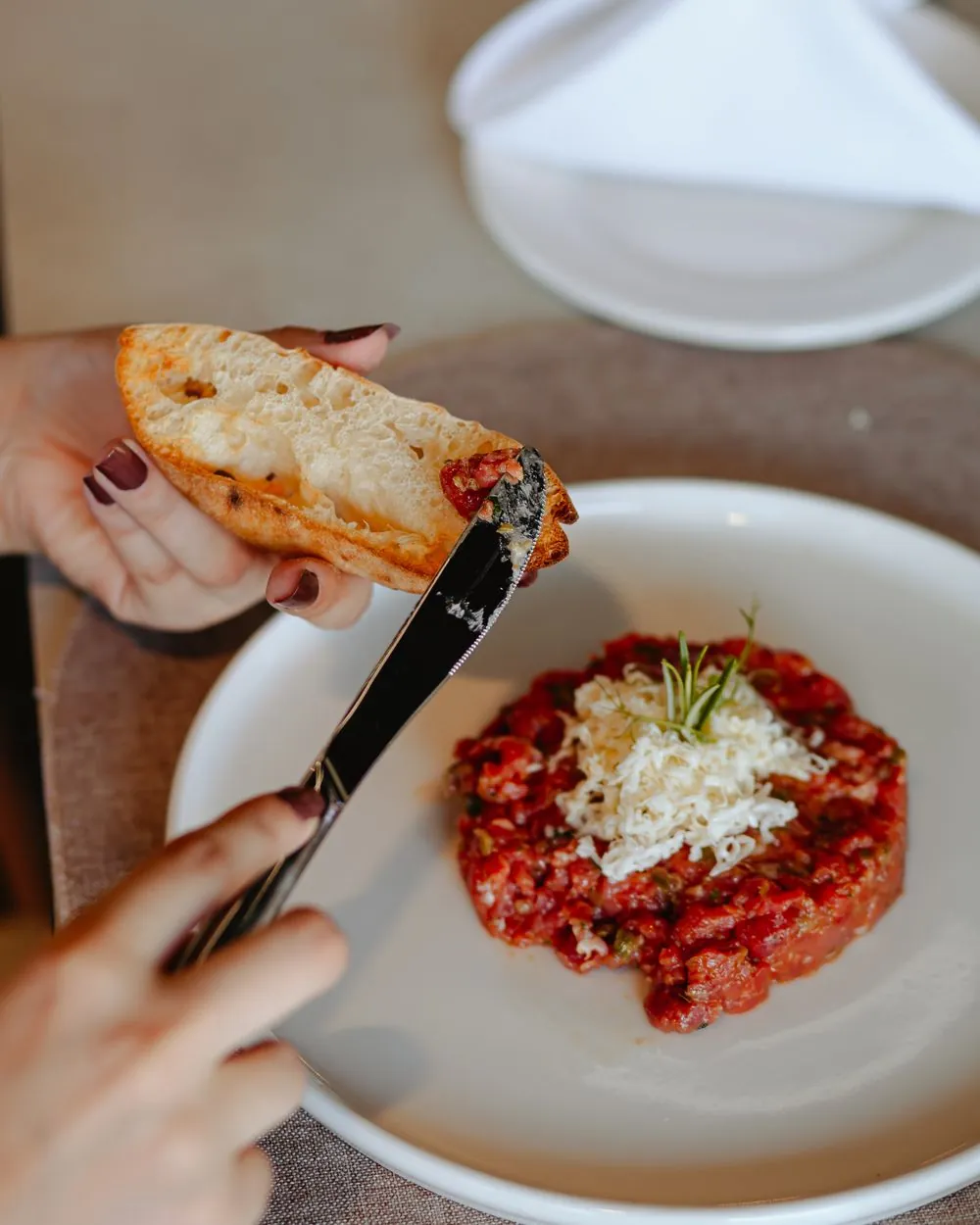 Toasted bread above a plate of tartare