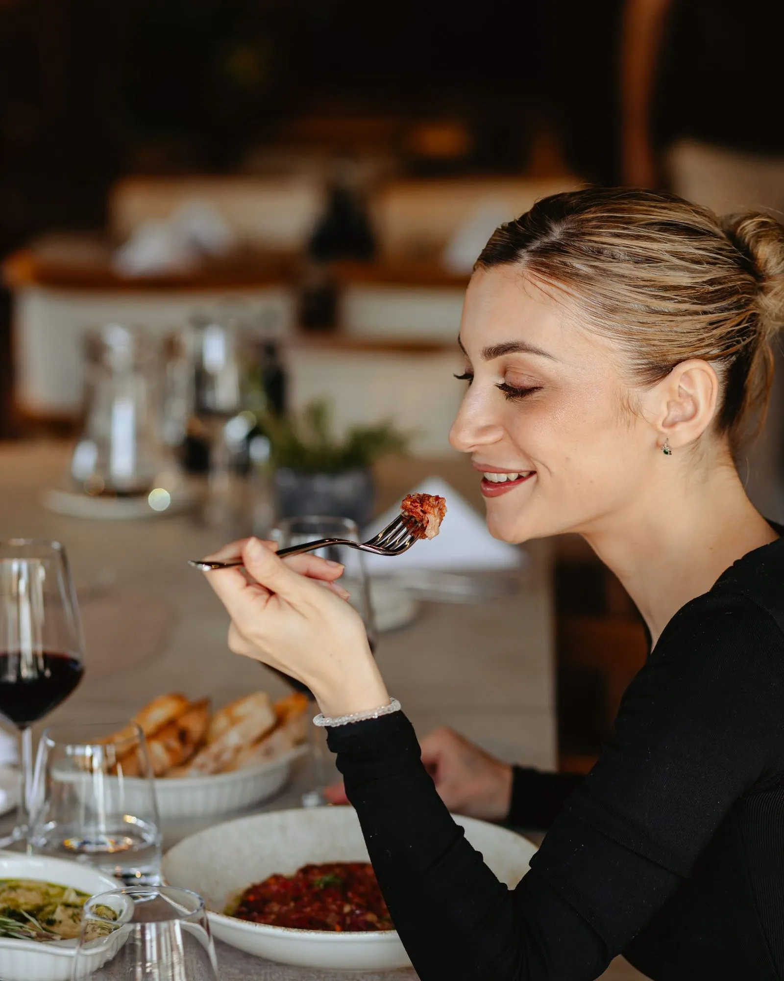 A guest at a table with a glass of red wine