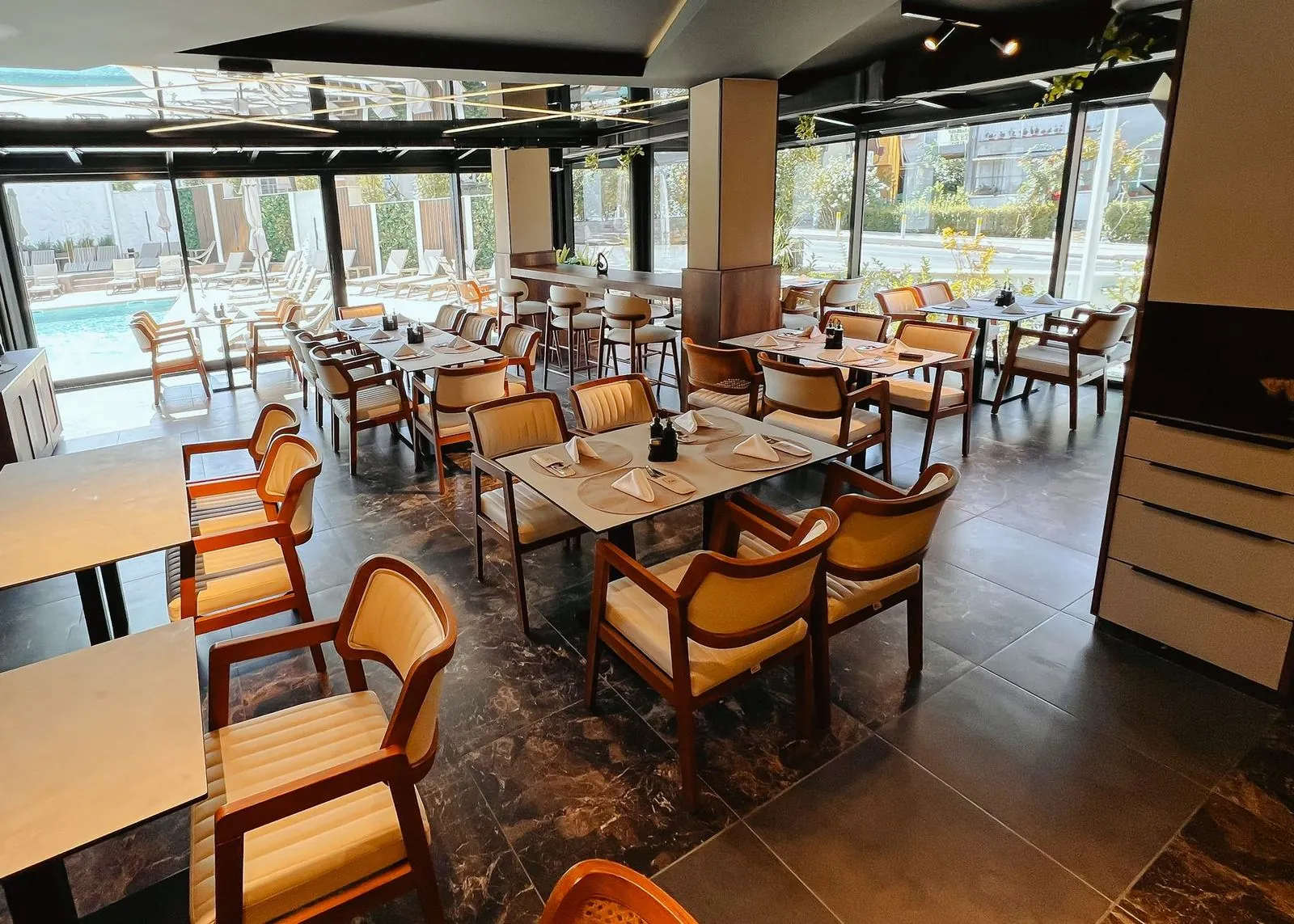 Interior of Žar&So restaurant, with a glass wall facing the pool